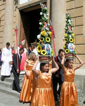 axentere in processione con il tipico copricapo fiorito e alabardieri di scorta alle reliquie del santo sardo