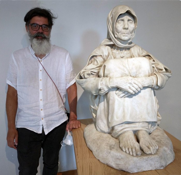 Riccardo Pozzo ritratto accanto alla statua marmorea di Francesco Ciusa