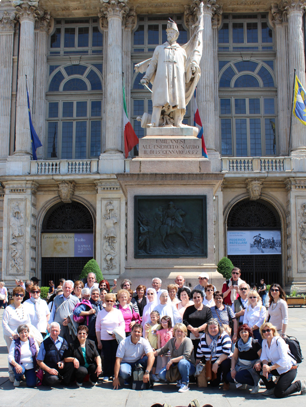 gruppo di gitanti in Piazza Castello a Torino, davanti al monumento all'Esercito sardo