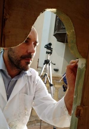 il restauratore prof. Valentino Faraci visto attraverso il tabernacolo di San Grato di Gurgo